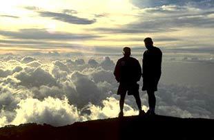 men on a mountain top above the clouds in costa rica