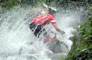 mountain bikers splashing in a river in Costa Rica
