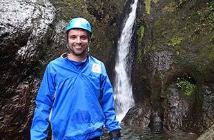 man smiling in front of waterfall on custom canyoning adventure in costa rica