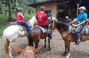three people with horses ready to go on a ride in Costa Rica