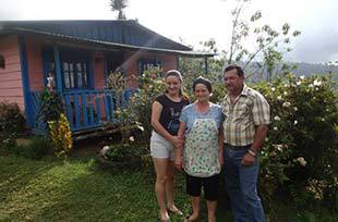 Rural Family in Costa Rica poses in front of their house