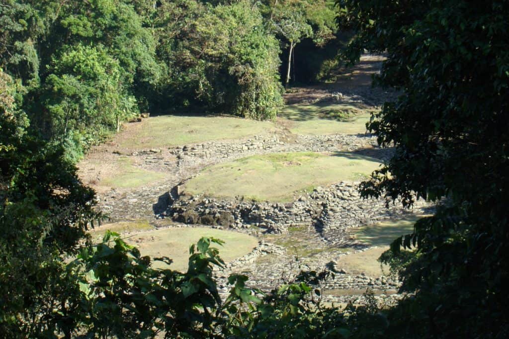 A view through the trees of the stone mounds of the Guayabo National Monument near Turrialba