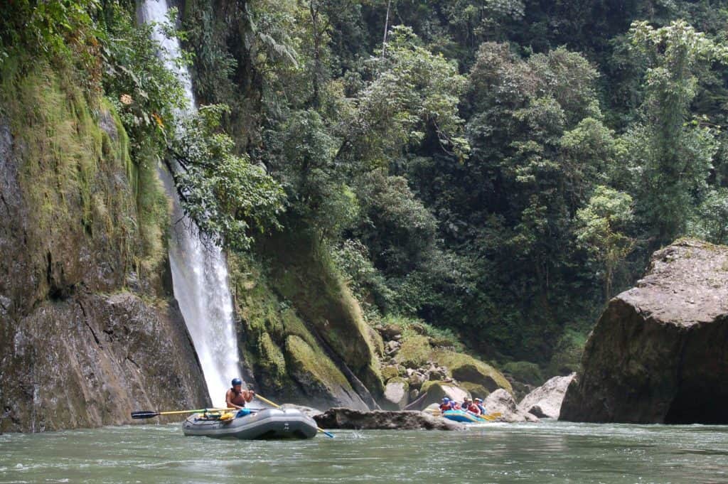 Two whitewater rafts passing a waterfall on the Pacuare River located near Turrialba