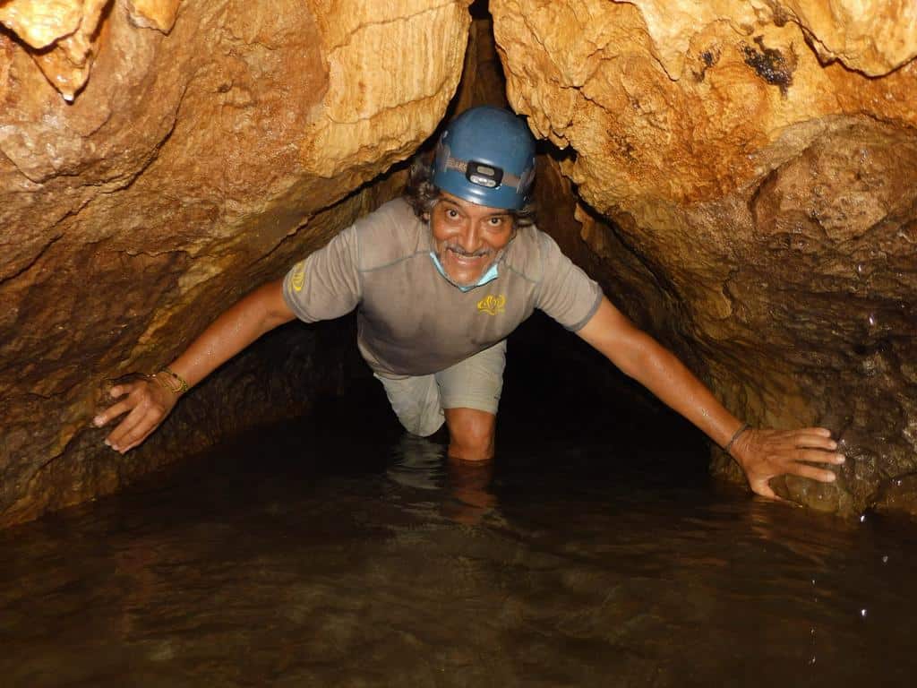 Serendipity Adventures Guide Mariano wading through water in the Venado Caves in Costa Rica