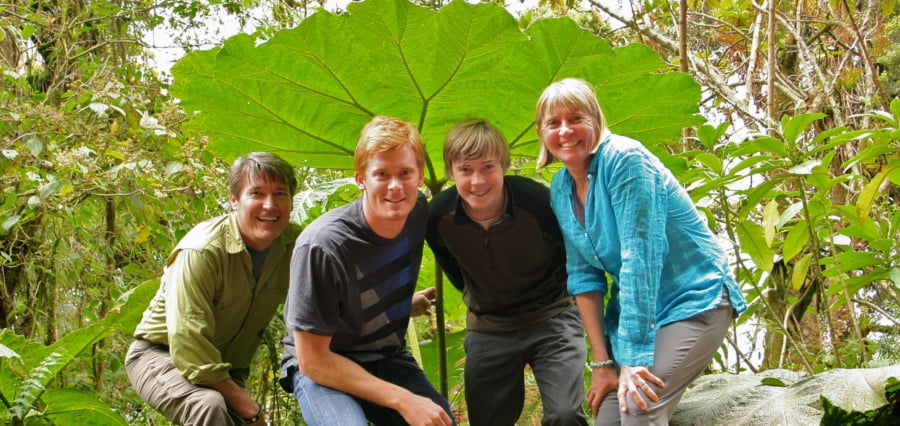 a family underneath a giant leaf during a hike in Costa Rica