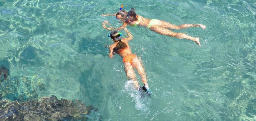two women snorkeling in clear blue ocean on a custom vacation in Costa Rica