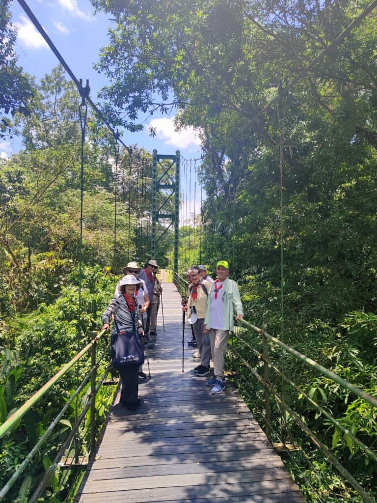 A group of senior travelers standing on a hanging bridge in La Selva Biological Station in Costa Rica