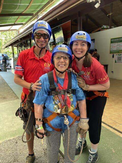 Two guides and a senior woman at the start of a zipline tour at Ecoglide in Costa Rica